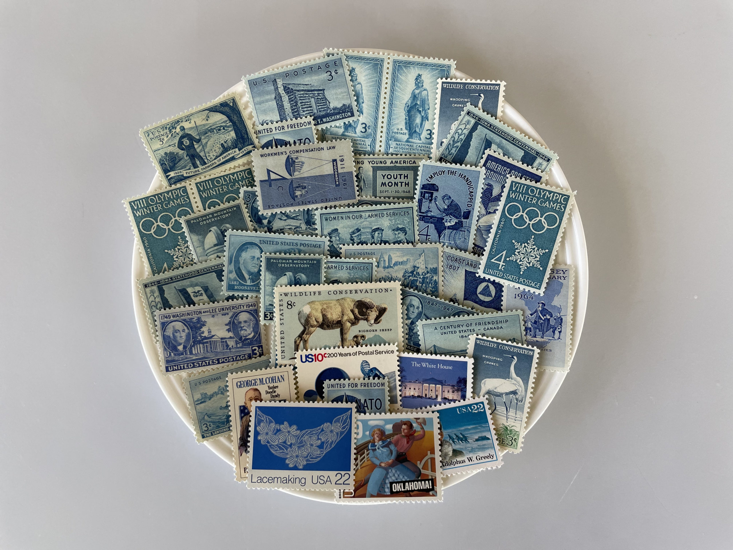 a variety of blue stamps arranged on a white plate.